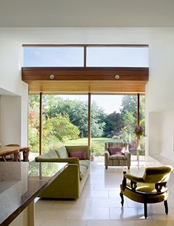 Interior view of a contemporary home in Sandymount, Dublin with large windows where architects have created a serene interior overlooking the garden, with ample natural light