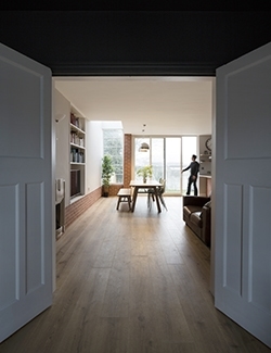 View from a doorway into a sunlit, modern dining area. Architects have carefully refurbished an old Dublin house.